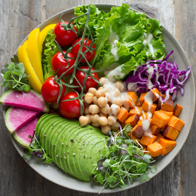 A beautiful salad with avocados, chickpeas, tomatoes and other veggies.